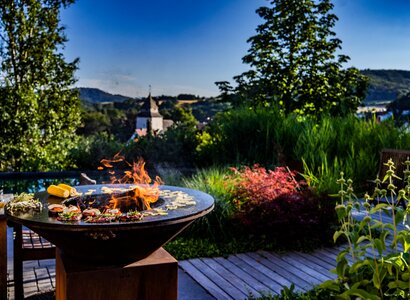 Grillplatte im Privatgarten mit Holzterrasse und Swimmingpool - Poolbauer in Marburg Poolbau mit Holzterrasse Grill und Bäumen in Dautphetal Buchenau